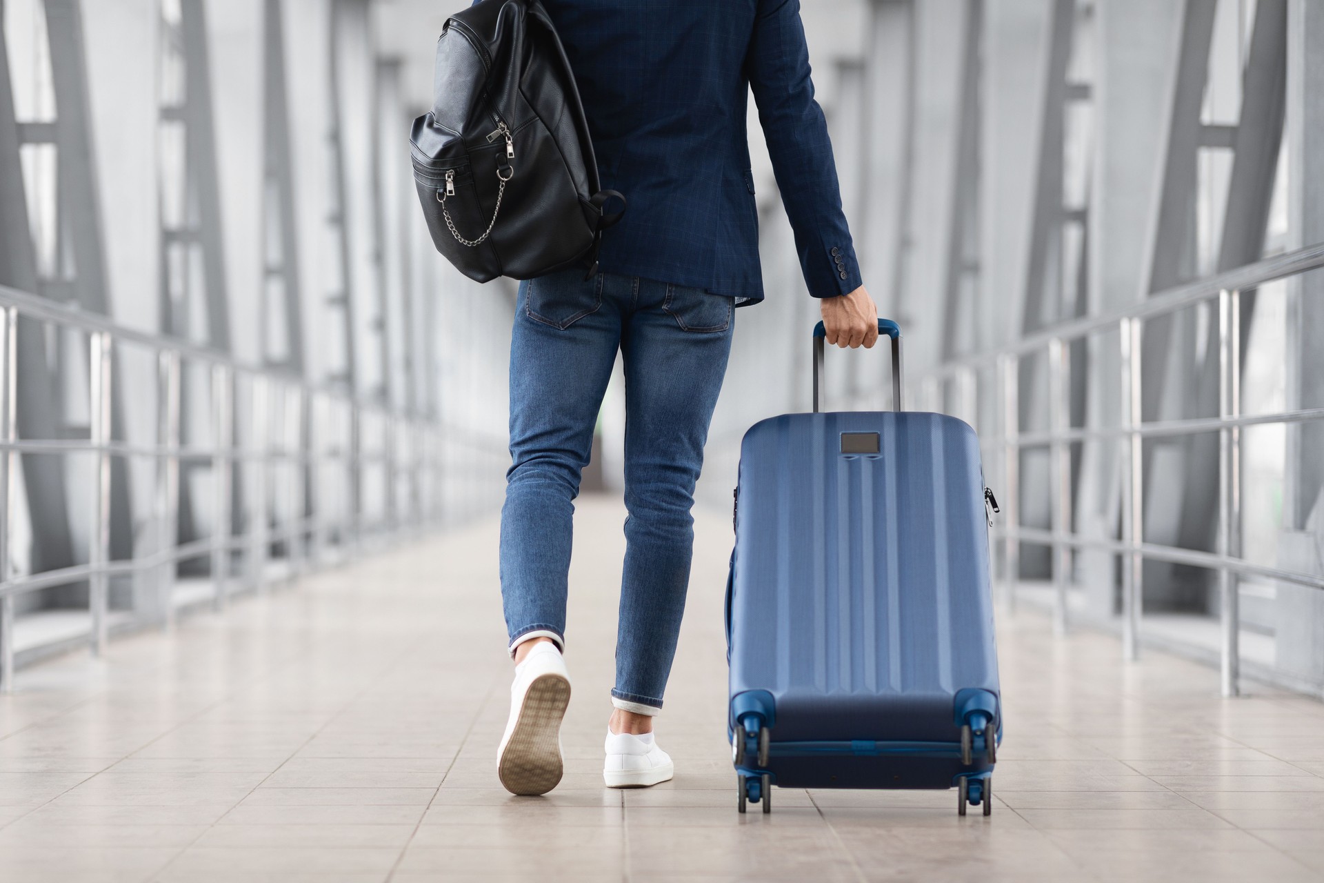 Unrecognizable Man With Bag And Suitcase Walking In Airport, Rear View